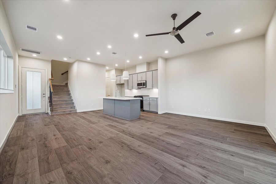 An expansive open-concept living area flows seamlessly into the kitchen, creating a bright and inviting space perfect for entertaining or relaxing at home.