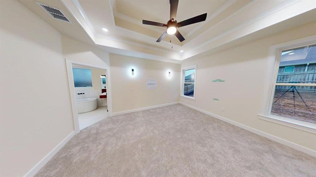 Carpeted spare room with a raised ceiling, ceiling fan, and recessed lighting