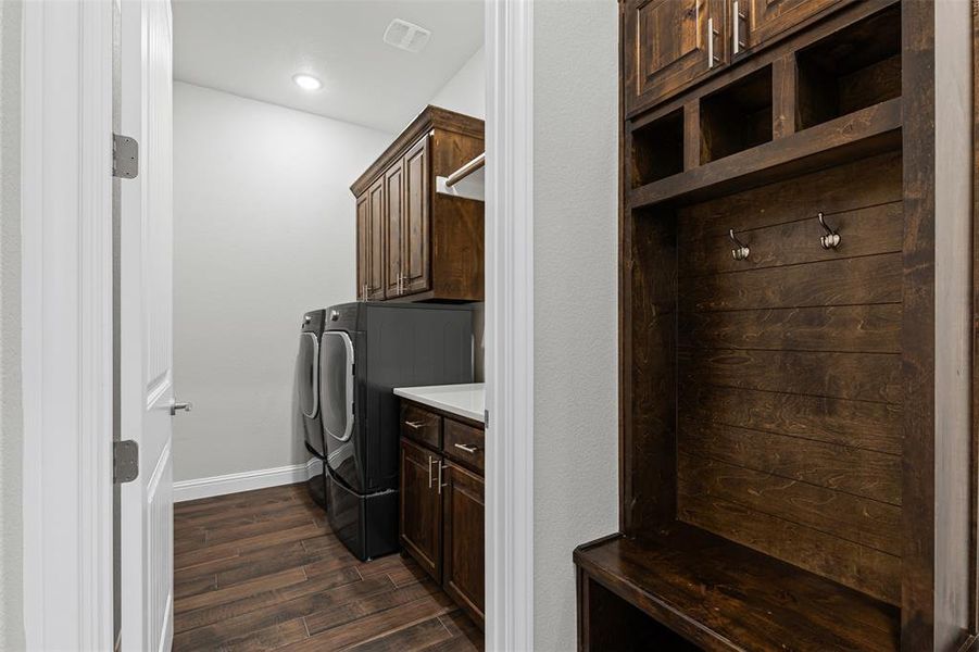 Laundry area featuring cabinet space, dark wood finished floors, and washer and dryer Laundry area featuring cabinet space, dark wood finished floors, and washer and dryer