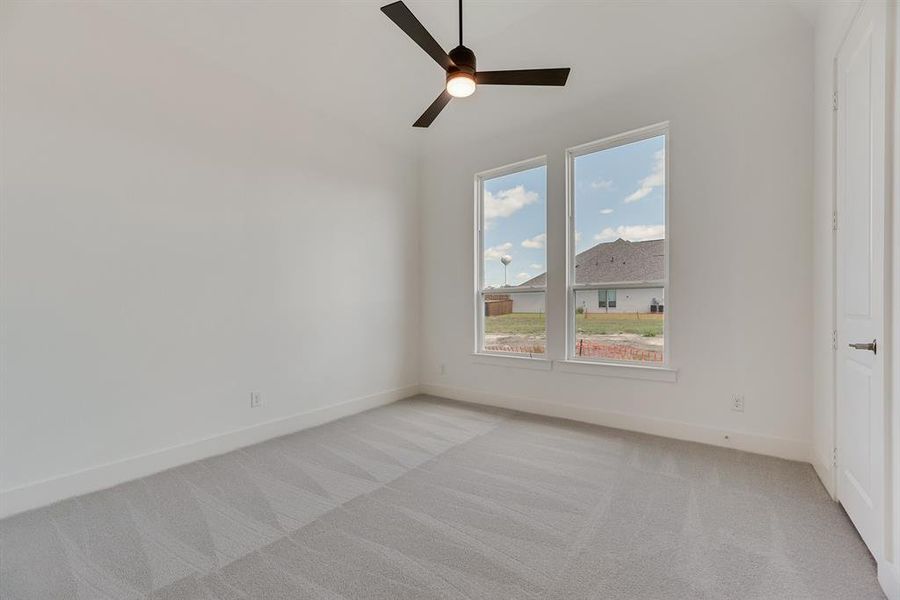 Empty room with light carpet, ceiling fan, and lofted ceiling
