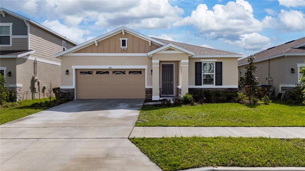 Front exterior of a new home in Seasons at Big Sky, Kissimmee, FL, highlighting curb appeal (Image 26).