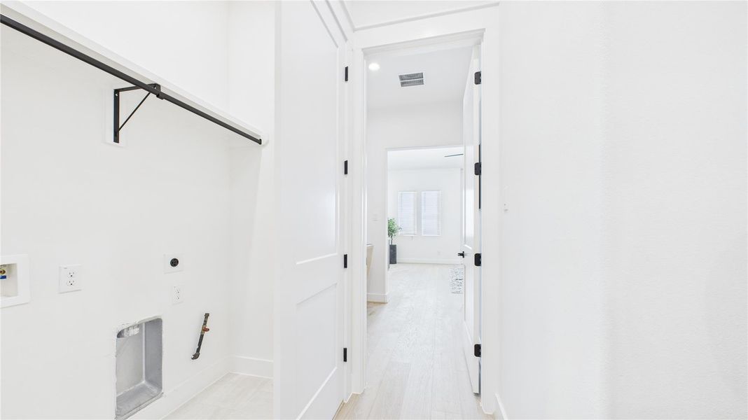 Utility closet on the second floor with tile floor and drain