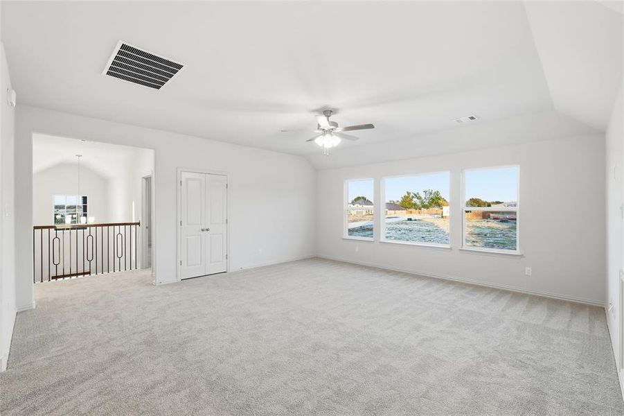 Additional living space featuring lofted ceiling, carpet floors, and ceiling fan