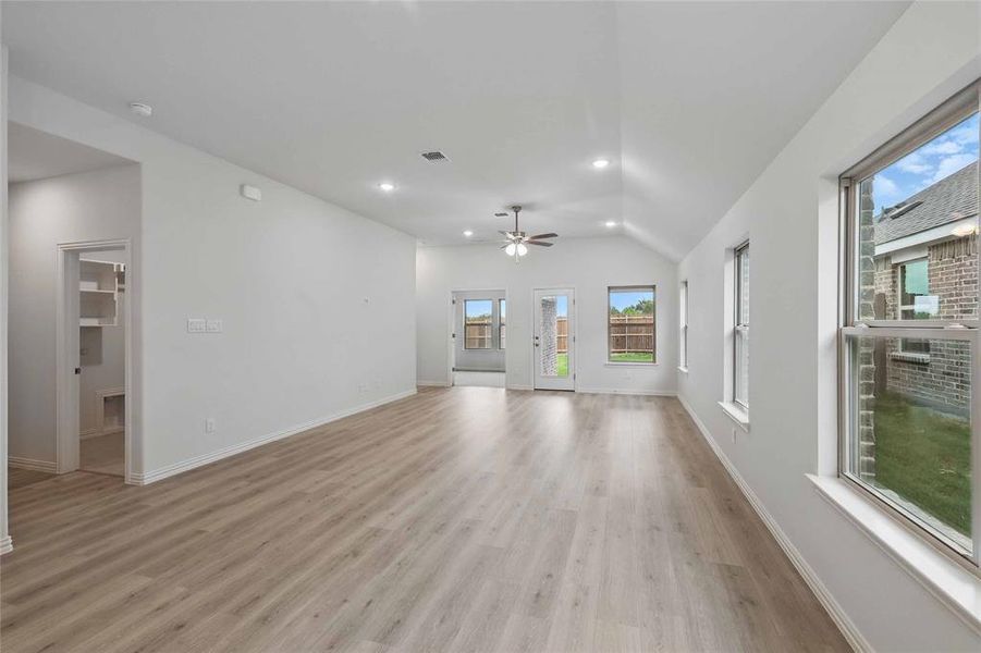 Unfurnished living room featuring lofted ceiling, light wood-style floors, ceiling fan, and recessed lighting