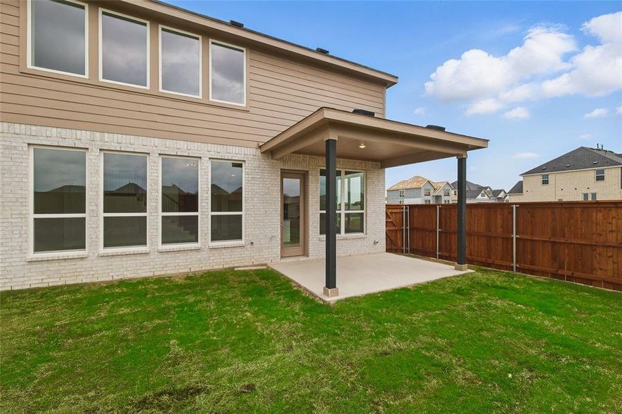 Rear view of property with a fenced backyard, a yard, a patio area, and brick siding Rear view of property with a fenced backyard, a yard, a patio area, and brick siding