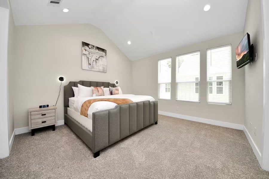 High ceilings and three windows give the primary bedroom an airy feel with plenty of natural light throughout the day.
