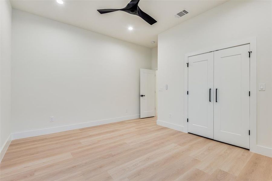 Unfurnished bedroom with ceiling fan, light wood-type flooring, and a closet