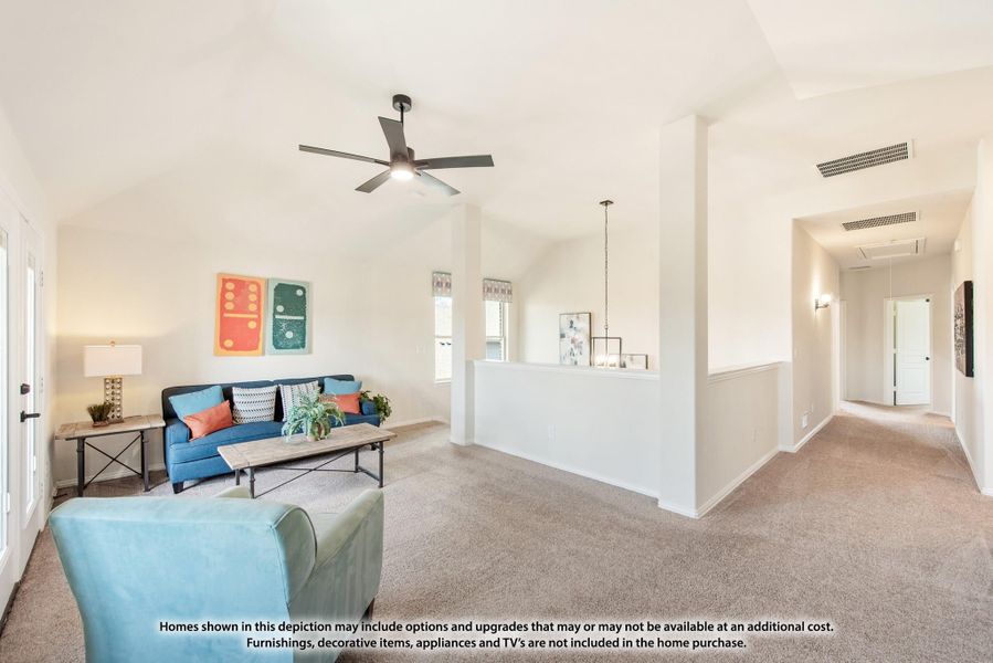 Living room with vaulted ceiling, ceiling fan, blue sofa, and carpet flooring open to a hallway