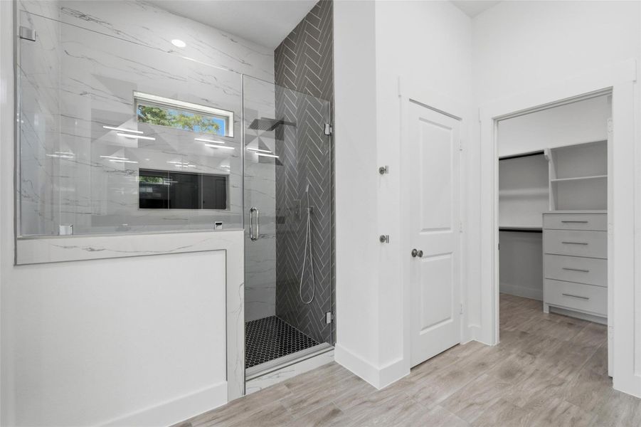 The spacious walk-in shower is fully enclosed in glass and complete with a soap niche and seating bench. The spacious walk-in shower is fully enclosed in glass and complete with a soap niche and seating bench.