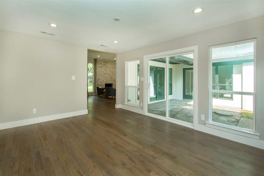 Empty room featuring a fireplace and dark hardwood / wood-style flooring