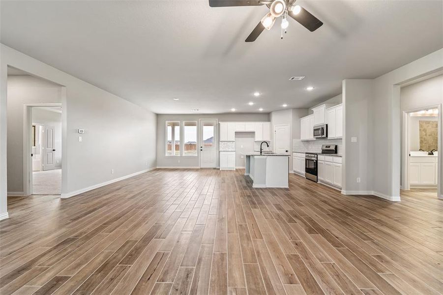 Unfurnished living room with wood finish floors, recessed lighting, and ceiling fan Unfurnished living room with wood finish floors, recessed lighting, and ceiling fan