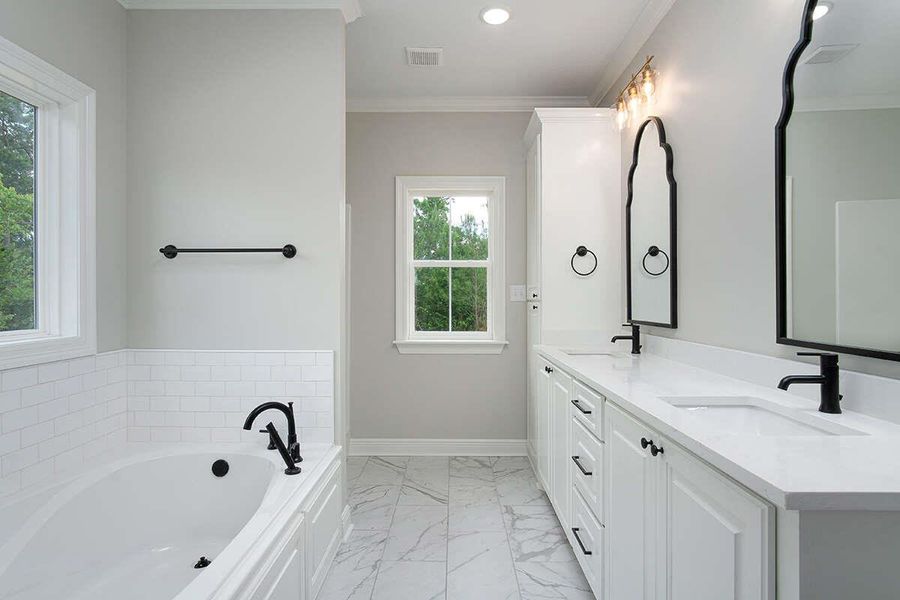 Full bath with marble finish floor, baseboards, crown molding, and a sink