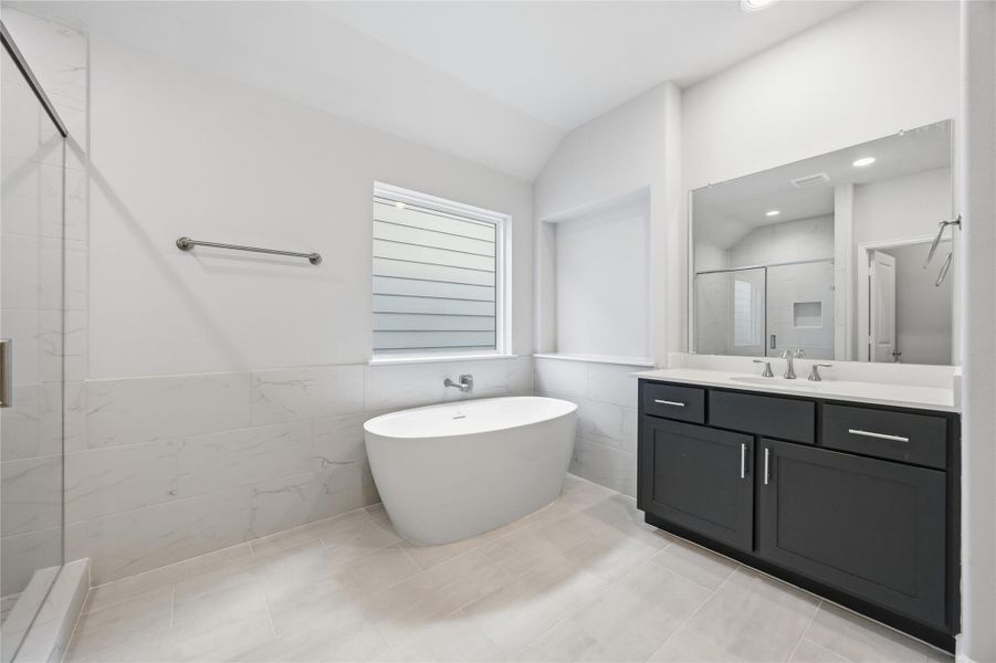 Ensuite Elegance: Step into the primary suite's ensuite bathroom, boasting abundant space and luxurious finishes, including a spa-like shower adjacent to the elegant freestanding tub.