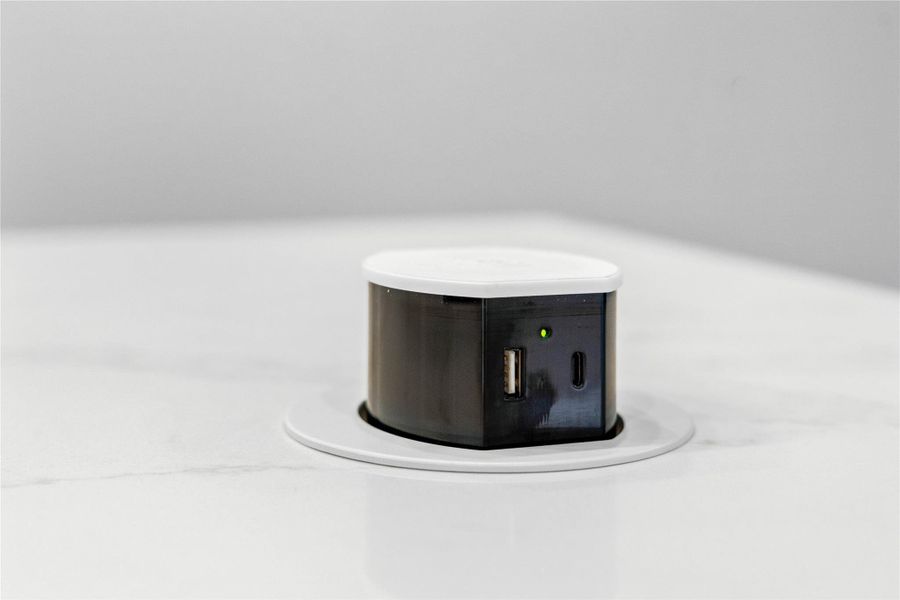 The added pop-up electrical outlet fixture sits nearly flush with the countertop when not in use, preserving a clean, uncluttered aesthetic. A simple press on the top causes the unit to rise up, providing access to power.