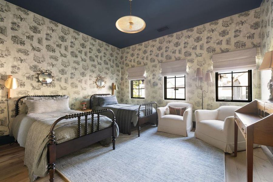 Bedroom featuring wood finished floors and wallpapered walls
