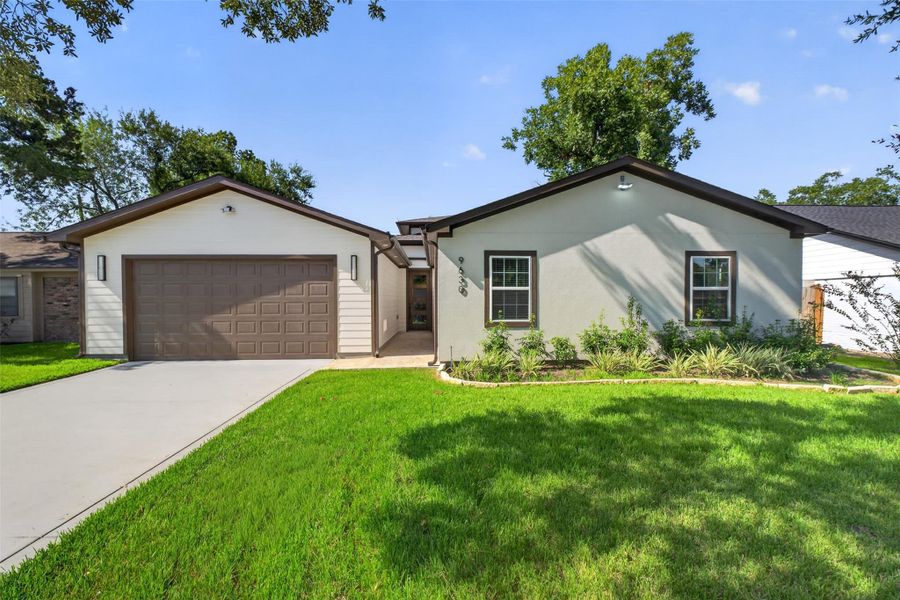 Charming single-story home with a spacious two-car garage, manicured lawn, and inviting curb appeal.