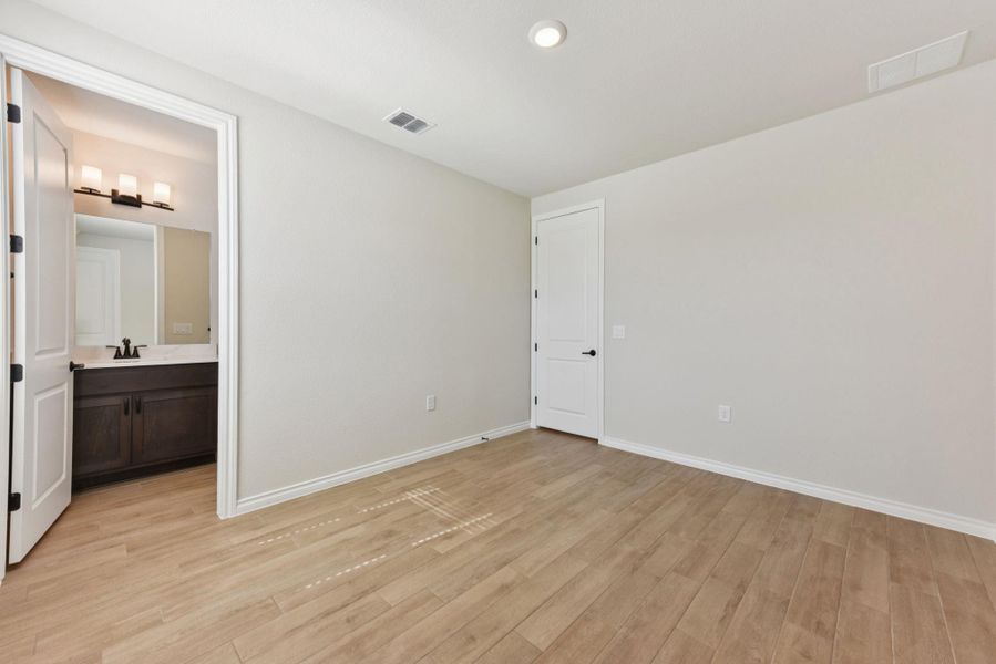 Unfurnished bedroom featuring light wood-style floors, recessed lighting, and ensuite bathroom