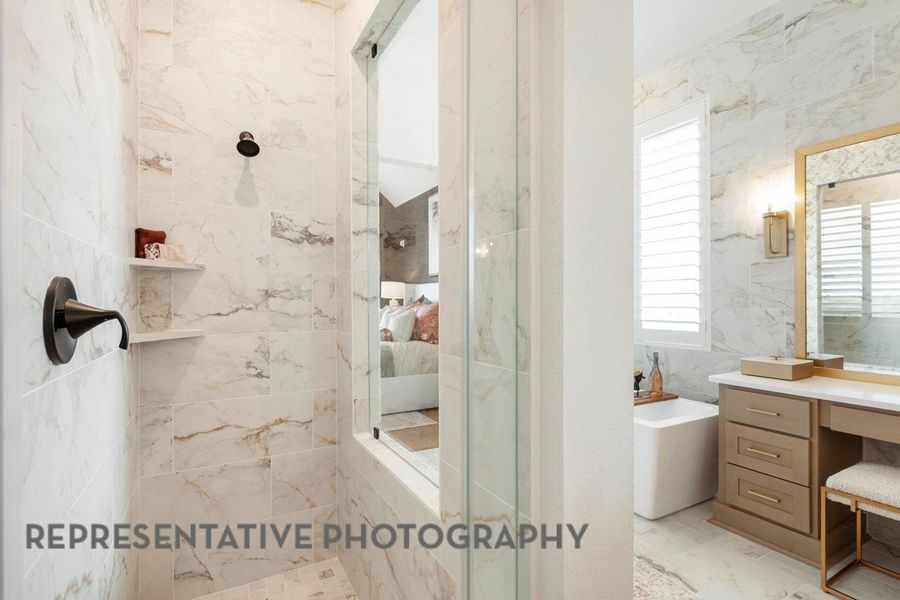 Bathroom featuring vanity, a walk in shower, and a soaking tub