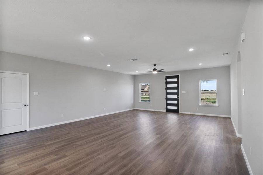 Unfurnished living room with dark hardwood / wood-style floors and ceiling fan