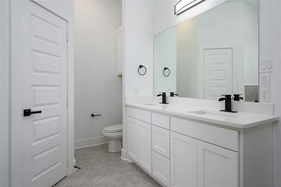 Bathroom featuring vanity, tile patterned floors, and toilet