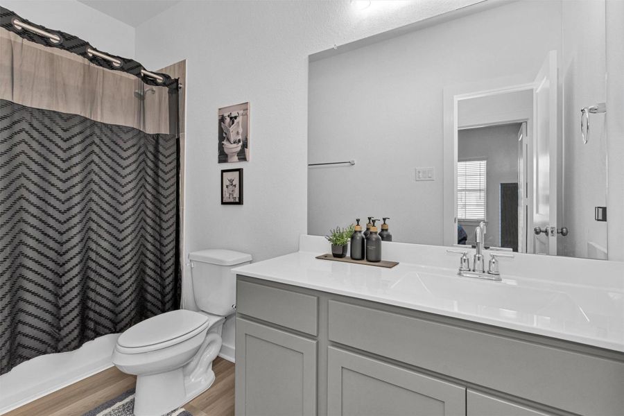 This first-floor full bathroom offers a spacious vanity, modern fixtures, and a tub/shower combination, providing convenient access for guests and secondary bedrooms.