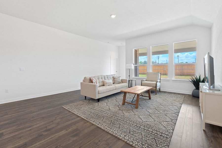 Living area featuring dark wood-style floors, lofted ceiling, and recessed lighting Living area featuring dark wood-style floors, lofted ceiling, and recessed lighting