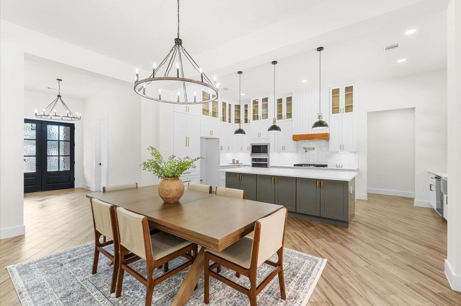 Elegant dining space with seamless connection to kitchen and living, framed by windows and warm wood details. Elegant dining space with seamless connection to kitchen and living, framed by windows and warm wood details.