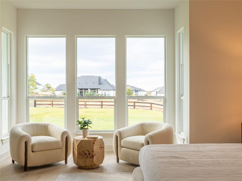 Bedroom with a residential view, multiple windows, and wood finished floors