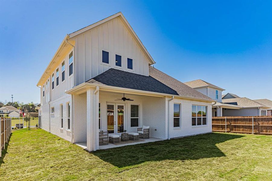 Back of house with a patio area, a lawn, and ceiling fan