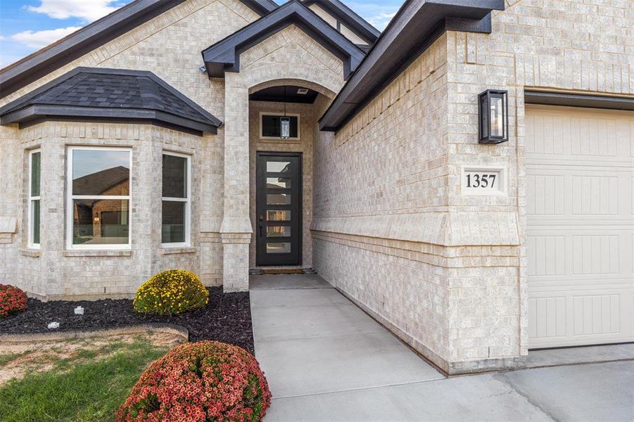 Property entrance with a garage and stone siding