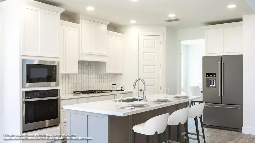 Kitchen featuring appliances with stainless steel finishes, light countertops, backsplash, white cabinetry, and recessed lighting Kitchen featuring appliances with stainless steel finishes, light countertops, backsplash, white cabinetry, and recessed lighting