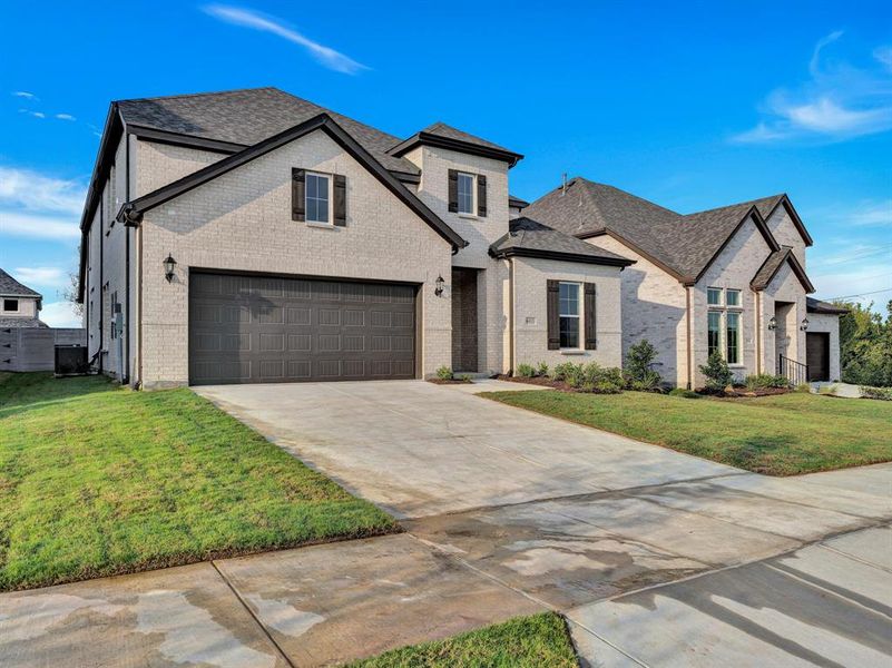 View of front of home with a garage and a front lawn