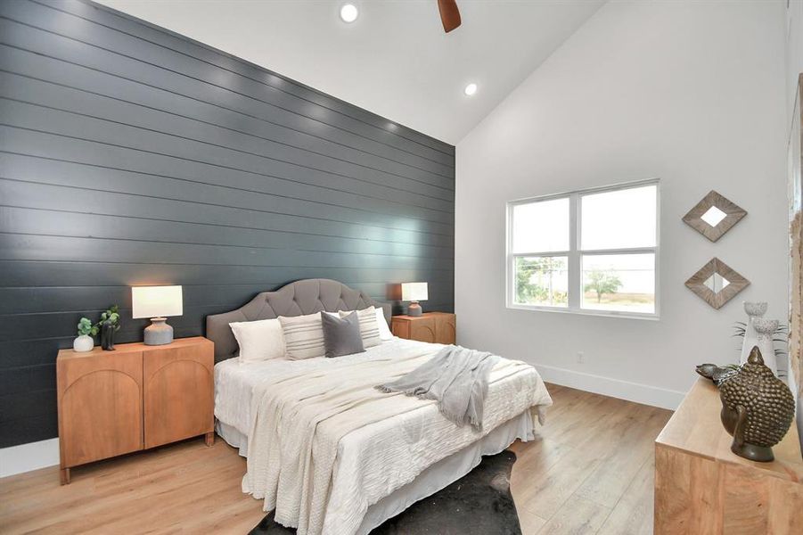 Retreat to the primary bedroom with a striking accent wall, vaulted ceilings, and en suite spa like bath.