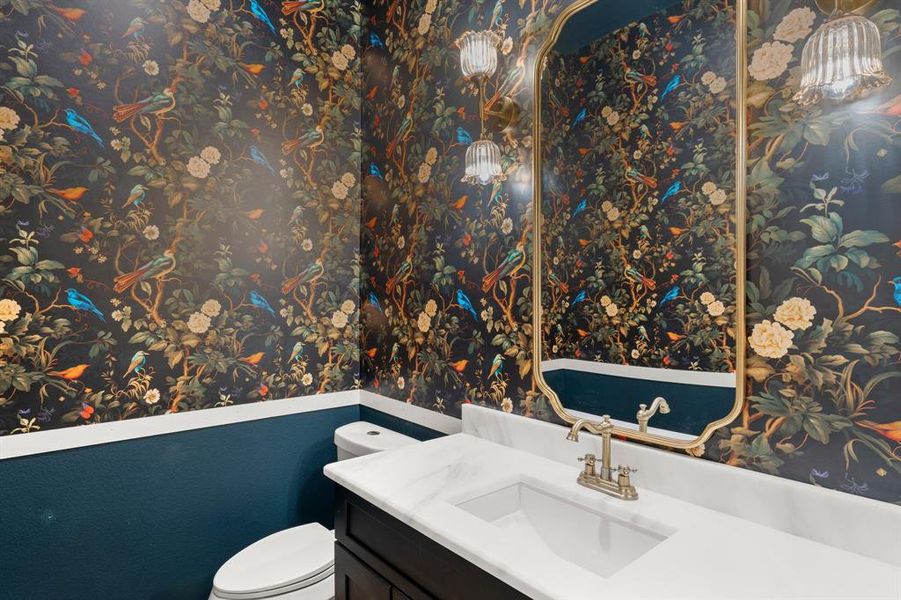 Bathroom featuring wallpapered walls and vanity