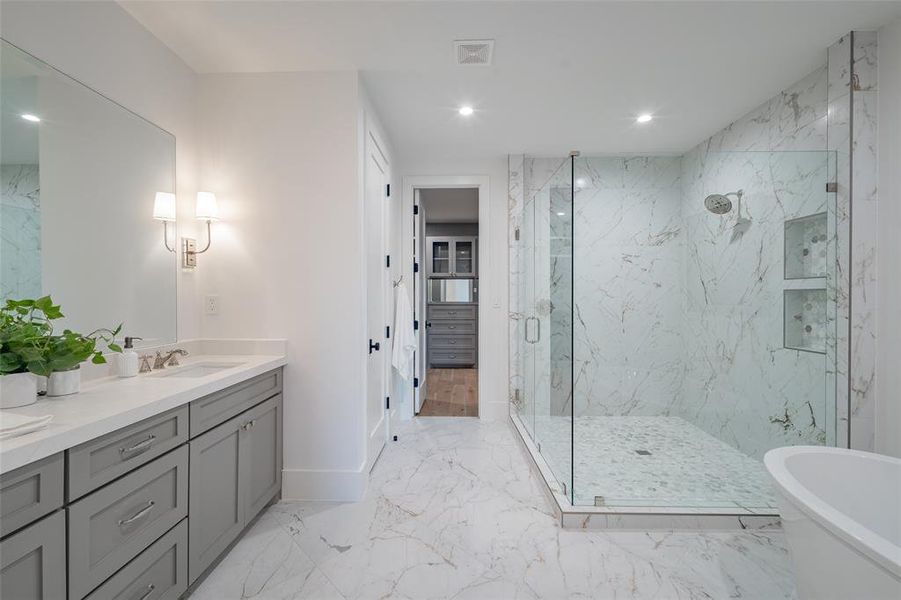 Bathroom featuring vanity and shower with separate bathtub