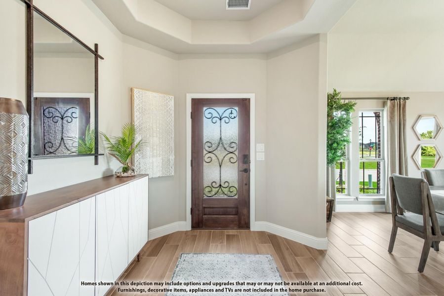 Entryway with wood front door featuring decorative glass panel, tray ceiling, and light wood-look tile floors