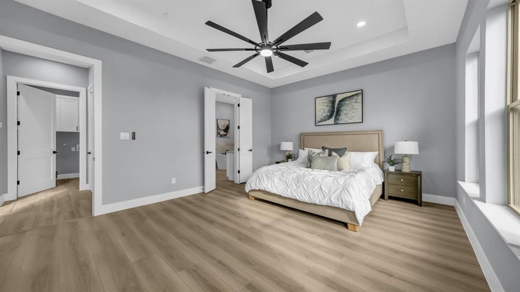 Bedroom featuring a tray ceiling, wood finished floors, a ceiling fan, and recessed lighting
