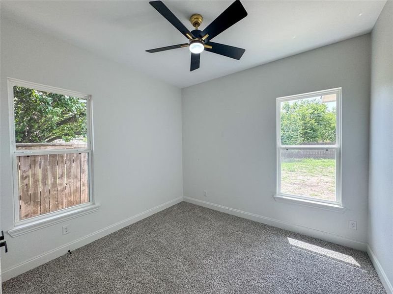Empty room with carpet floors, a ceiling fan, and baseboards Empty room with carpet floors, a ceiling fan, and baseboards