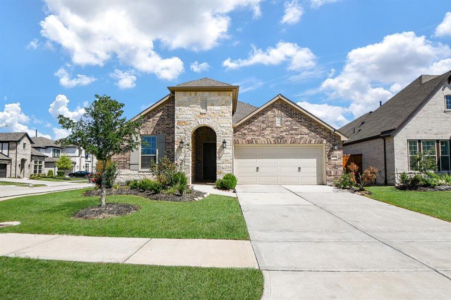 This is a charming single-story home with a brick and stone exterior. It features a two-car garage, a well-maintained front yard, and a welcoming entrance. The neighborhood appears to be quiet and residential. This is a charming single-story home with a brick and stone exterior. It features a two-car garage, a well-maintained front yard, and a welcoming entrance. The neighborhood appears to be quiet and residential.