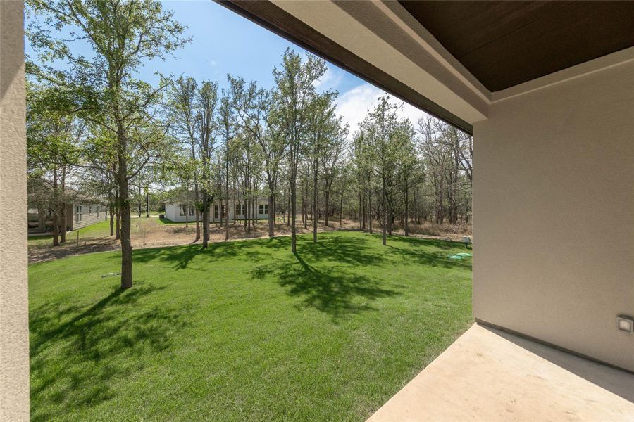 View of grassy yard with a patio area