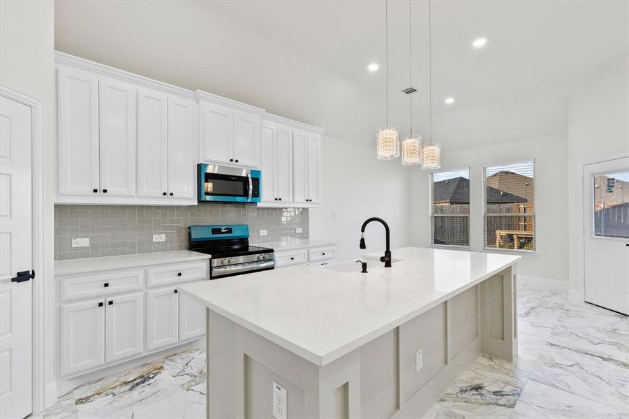 Kitchen with appliances with stainless steel finishes, a sink, marble finish floor, a kitchen island with sink, and backsplash Kitchen with appliances with stainless steel finishes, a sink, marble finish floor, a kitchen island with sink, and backsplash