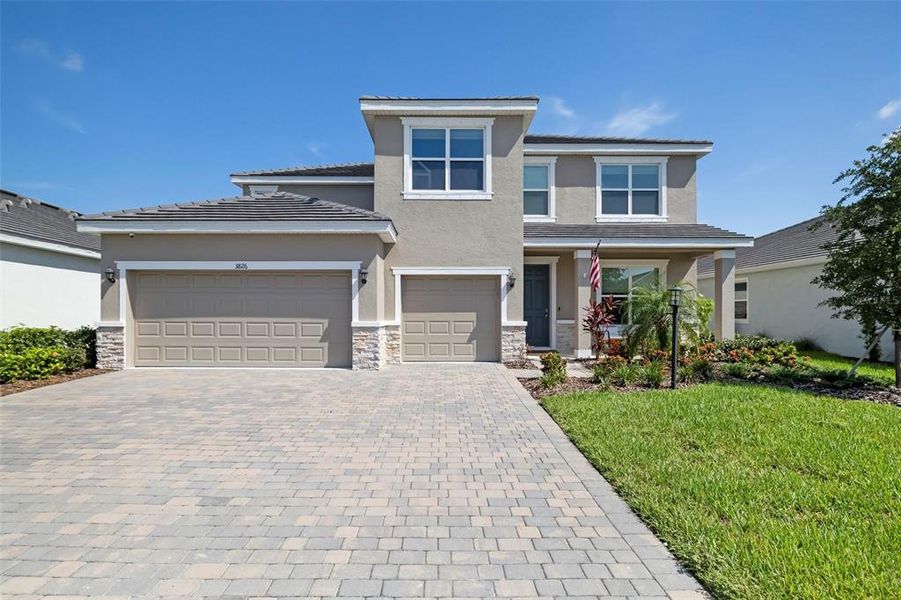 Front exterior of a new home in Star Farms at Lakewood Ranch, Bradenton, FL, highlighting curb appeal (Image 2). Front exterior of a new home in Star Farms at Lakewood Ranch, Bradenton, FL, highlighting curb appeal (Image 2).