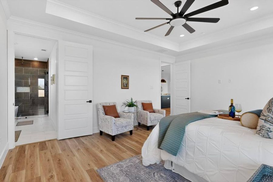 Bedroom with a tray ceiling, light wood-style flooring, recessed lighting, ceiling fan, and ornamental molding Bedroom with a tray ceiling, light wood-style flooring, recessed lighting, ceiling fan, and ornamental molding