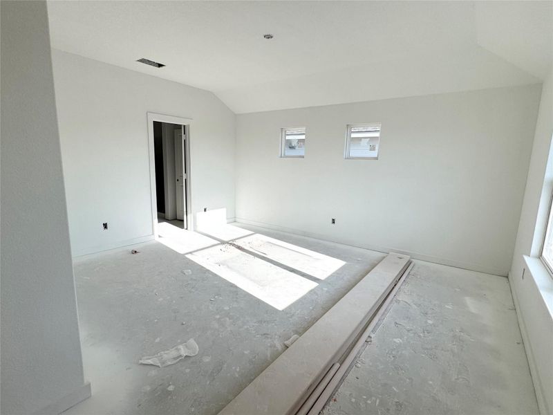 Unfurnished room with vaulted ceiling and baseboards Unfurnished room with vaulted ceiling and baseboards
