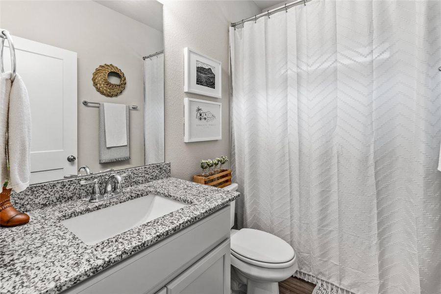 Granite counters and a clean white vanity create a fresh, practical space. Granite counters and a clean white vanity create a fresh, practical space.