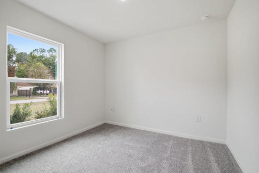 A room with a window and a carpet.