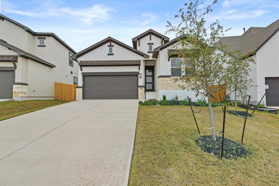 View of front of house with a garage and a front lawn