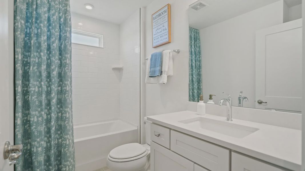 Full bathroom with shower/tub combo and clearstory window in a DRB Homes Ambersweet model at the Trinity Place community. Full bathroom with shower/tub combo and clearstory window in a DRB Homes Ambersweet model at the Trinity Place community.