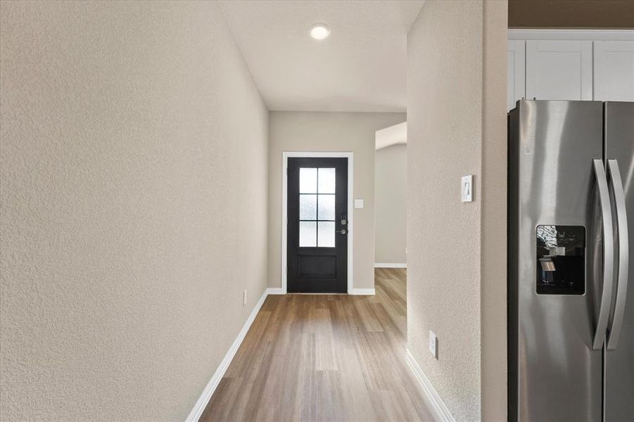 Foyer entrance with a textured wall, light wood-style floors, and recessed lighting Foyer entrance with a textured wall, light wood-style floors, and recessed lighting