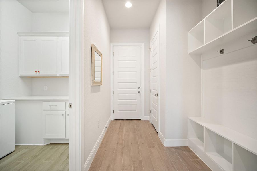 Mudroom featuring light wood-type flooring and washer / dryer